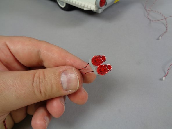 Mount two red Pico LED lights inside the tail lights as shown in the third photo, and replace the transparent red cones on top of the LED lights.