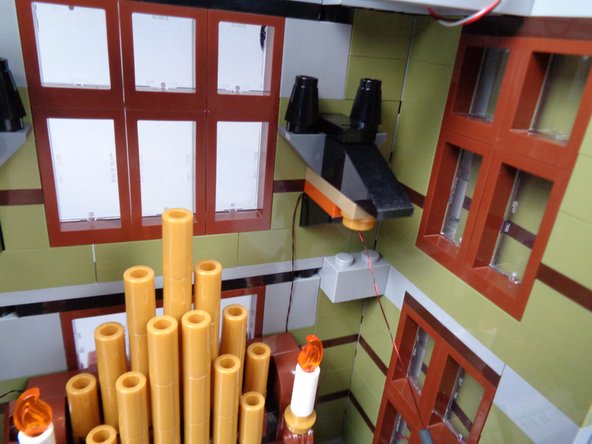 As shown in the third photo for this step, carefully re-attach the head assembly.  The candle wire should be held in place by the head assembly.