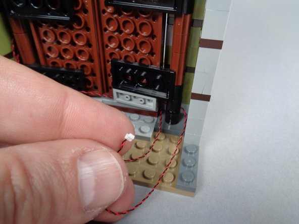 As shown in the third photo for this step, the light wire should pass into the entryway along the wall.