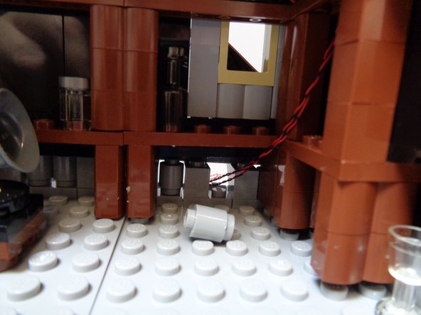 As shown in the second and third photo, route the two attic light wires through the gap and out the back of the roof.