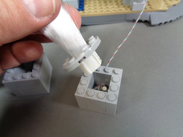 Your fireworks add-on kit includes three fiber optic sprays with light bluish gray round LEGO plates attached to the bottom of each spray.