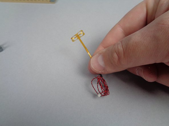 As shown in the first photo for this step, remove the 2-light flickering flame assembly from one of the bags inside of BOX #1.  The assembly is flexible and fragile, so handle it carefully.