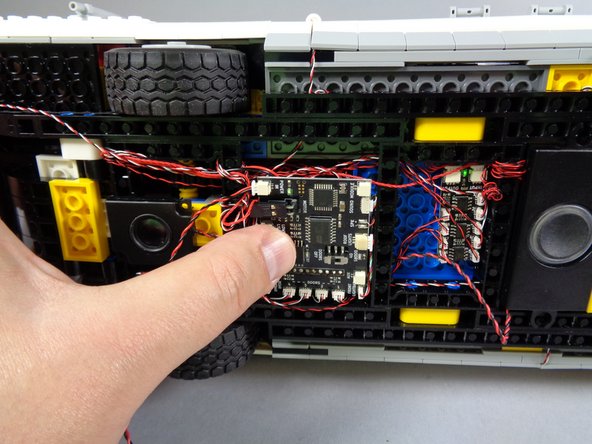 As shown by the orange square in the first photo for this step, tuck the sound module back in the space behind where you will attach the main controller.