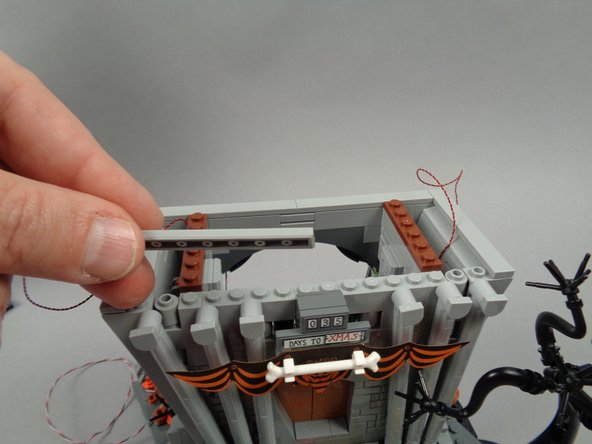 As shown in the first two photos for this step, remove the two long tiles from the top of the town hall first floor.