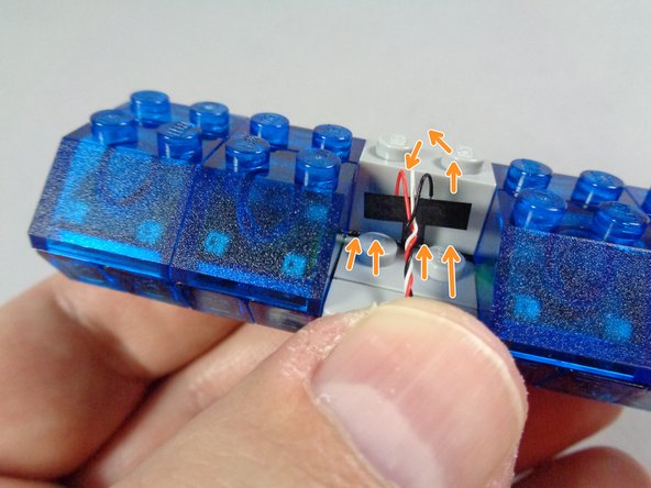 As shown by the orange arrows in the third photo for this step, carefully bend the &quot;T&quot; shaped piece so it stands up.