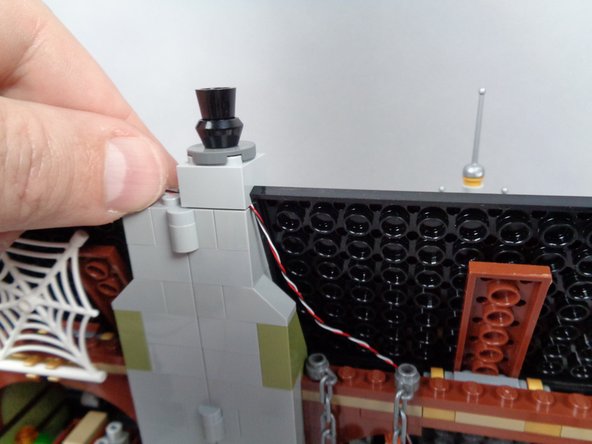 As shown in the two photos for this step, re-attach the first chimney section so it holds the control wire in place.