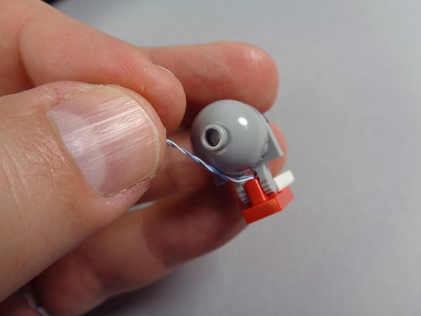 As shown in the photos for this step, finish re-assembling the hood spot light, taking care to make sure the light wire passes between the clip prongs and that the wire is not pinched when the light is re-attached to its bracket.