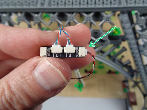 Take another light strip pair with connected adapter board and, as shown by the green arrow in the photo for this step, connect a 3-wire control cable to the OUTPUT plug on the adapter board.