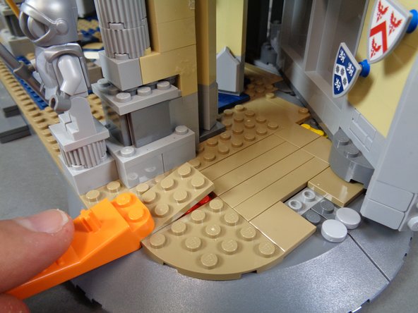 As shown in the photos for this step, remove the 2x2 dark tan tile and use a brick separator to remove the 2x4 dark tan plate.