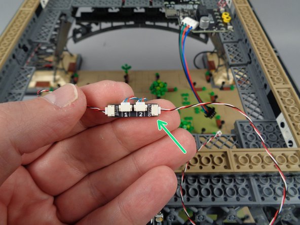 As shown by the blue circle in the second photo for this step, connect the end of the control cable coming from the third adapter board to the INPUT plug on the fourth adapter board.