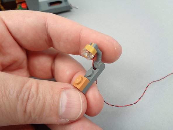 As shown in the first photo for this step, take a 1x1 plate from the extra parts from your LEGO set.