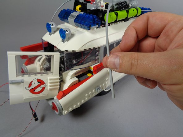 As shown in the first photo for this step, remove the light bluish gray hose from the right side of the vehicle frame.