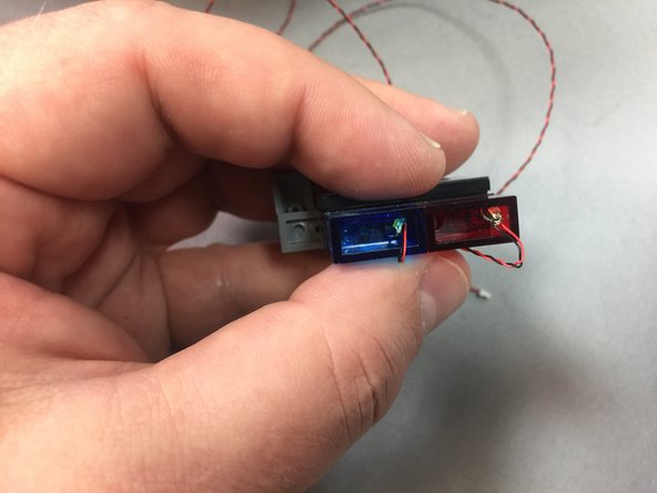 Take two more Pico LED lights, and as shown in the second photo, insert the lights into the transparent blue and red bricks.  Bend the wires so the lights extend up into the space inside the bricks, but the wires extend out the back and up the outside of the bricks.