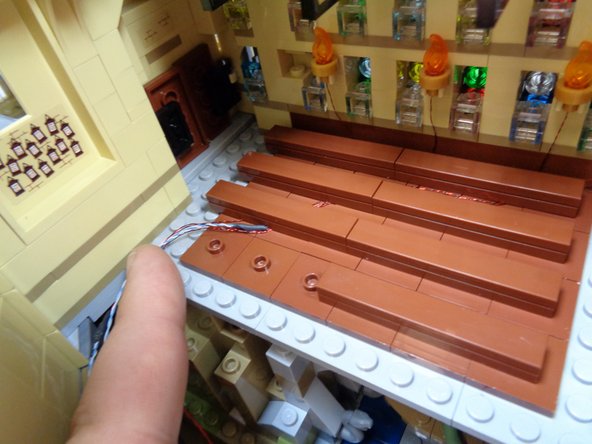 As shown in the second photo, gather the wires to the left of the last row of benches.