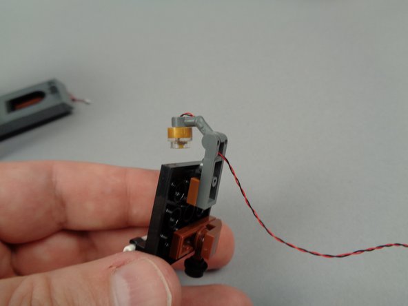 As shown in the second photo for this step, attach the 1x1 plate to the lower stud of the spotlight included with your light kit.