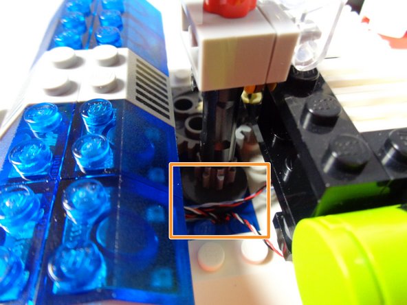 The red arrow in the first photo for this step shows the rear lightbar mounted with the control wire on the BACK side, and with the wire passing beneath the lightbar.