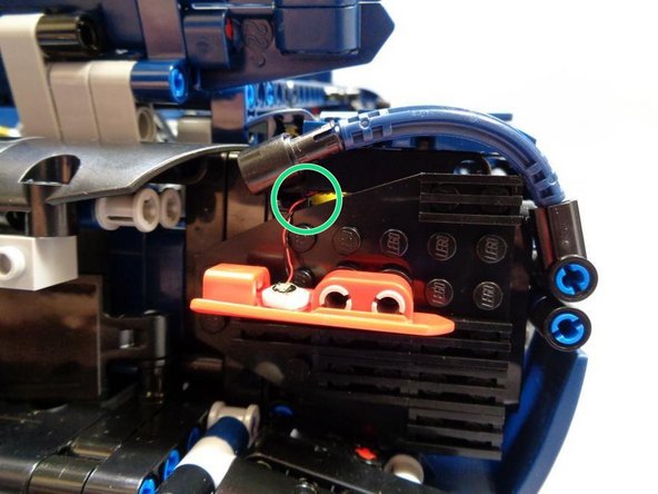 Using one of the sticky squares included with your kit, mount the second red Pico LED from Bag 1 to the lower half of the red rear turn signal panel.