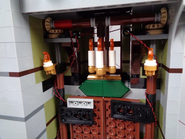 Next you will add flickering lights to the entryway chandelier by removing the LEGO parts and replacing them with pre-lit Brickstuff candles.