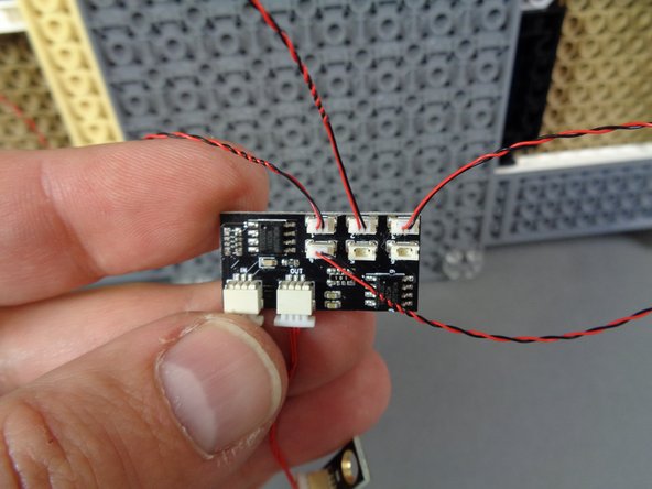 As shown by the blue circles in the second photo, attach the warm white spotlights to the castle base, spacing them evenly.