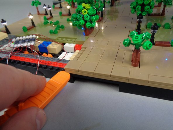 As shown in the photos for this step, next you will remove the panel next to Panel 1F-- this will allow you to pass the control cable from Section 1 to Section 2 which you will work on next.