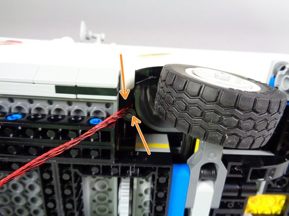 As shown in the third photo for this step, make sure the three wires come out behind the wheel well and that they do not touch or come close to the tire.