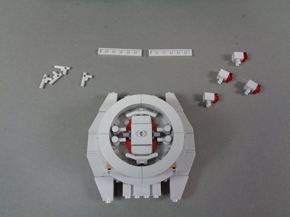 As shown in the photos for this step, carefully remove the top and bottom center parts from the docking bay cap.