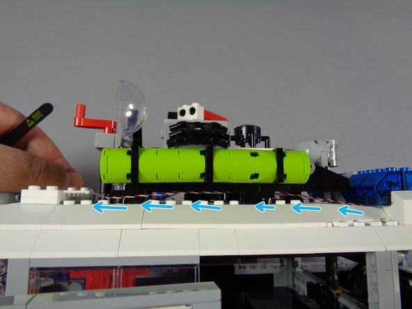 As shown by the blue arrows in the first photo for this step, continue weaving the lightbar control wire along the edge of the roof supports until the wire reaches the rear of the roof.