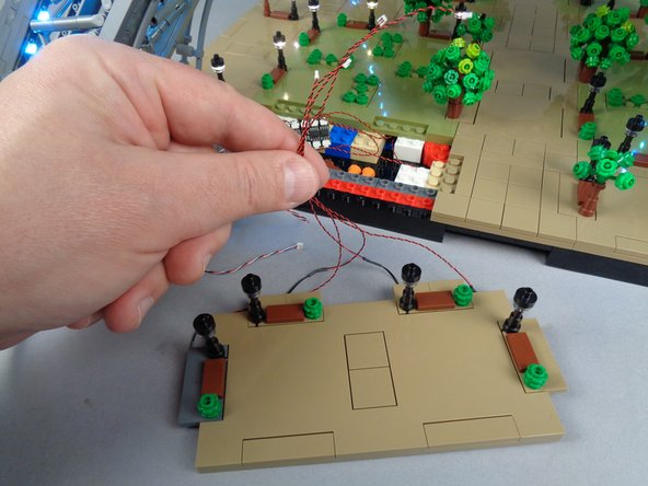 As shown in the photos for this step, connect the LED light wires from the four lamp posts on Panel 1F to the four remaining open plugs on the BRANCH12X driver board.