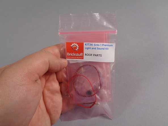 As shown in the first photo, find the large pink bag labeled &quot;Roof Parts&quot; in your Brickstuff kit.