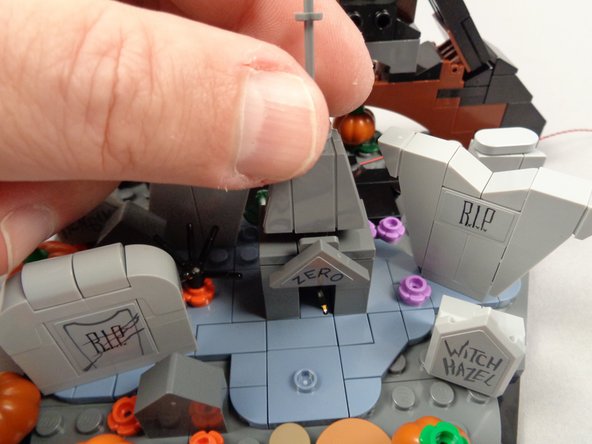 As shown in the photos for this step, re-attach the roof sections of Zero's grave.