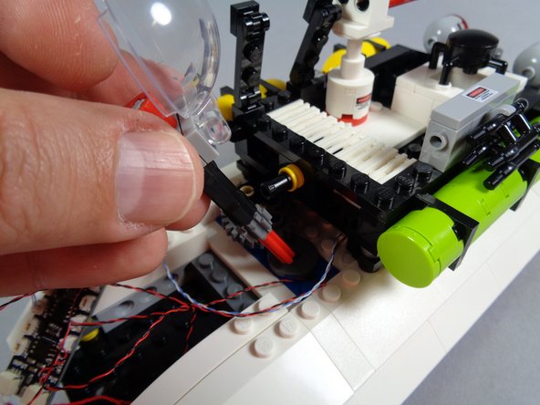 As shown in the first photo for this step, re-insert the roof radar assembly.