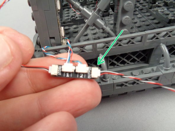 Take another 3-wire control cable, and as shown by the green arrow in the first photo for this step, connect one end of it to the OUTPUT plug on the adapter board for the pair of light strips you just finished mounting.