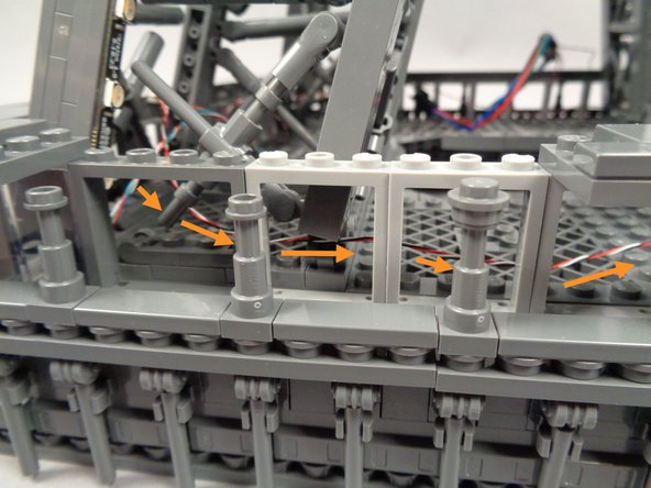 As shown by the orange arrows in the second photo for this step, route the control wire coming from the OUTPUT plug on the adapter board behind the window frames.