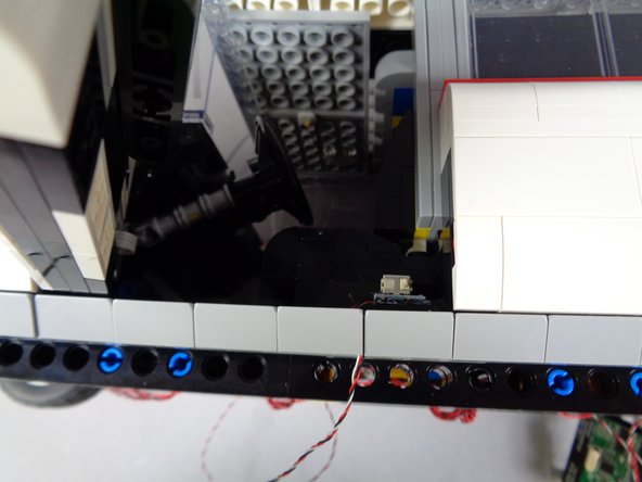 As shown in the second photo for this step, re-attach the slope to hold the switch wire in place.