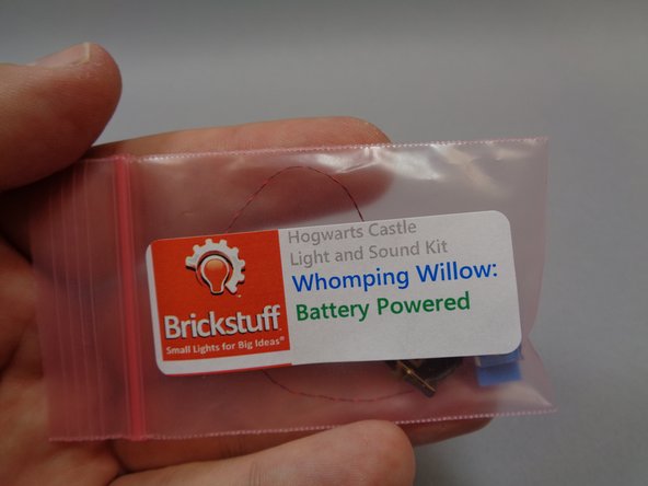 Take the pre-lit car and battery holder assembly out of its bag, and as shown in the second photo, remove the white top and black wheels from the car in your LEGO® set and transfer them to the pre-lit car as shown in the third photo.