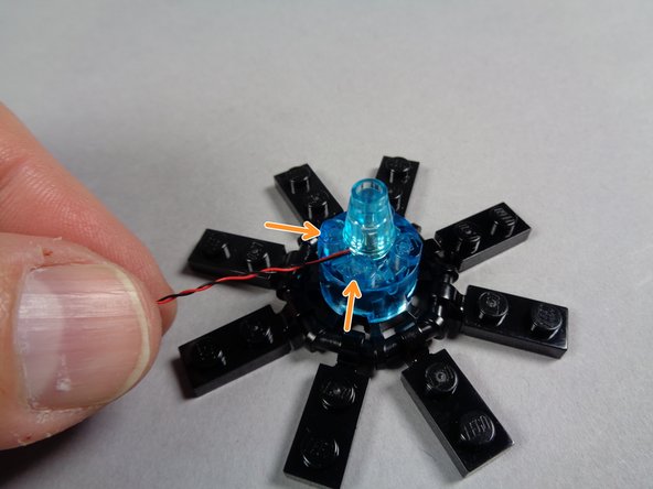 As shown in the third photo, carefully re-attach the transparent blue cone to the center of the engine, on top of the Pico LED light.