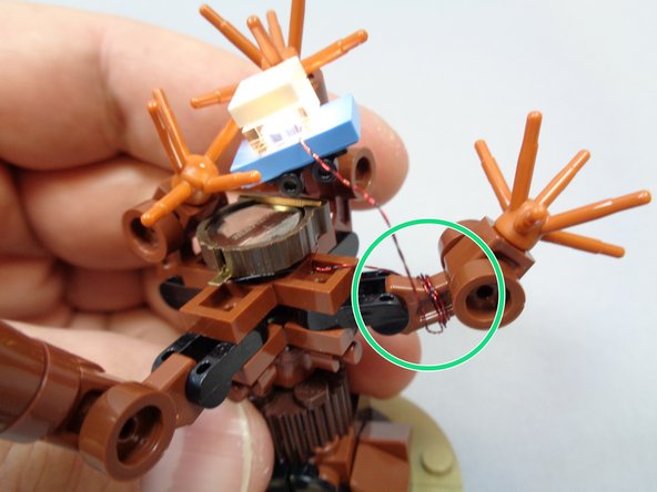 As shown in the first photo, wind the light wire around one of the branches to take up any slack.