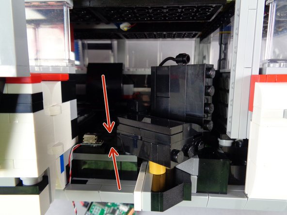 As shown by the red arrows in the first photo for this step, slide the gunner seat out to make sure the seat can move in and out without hitting the door switch.