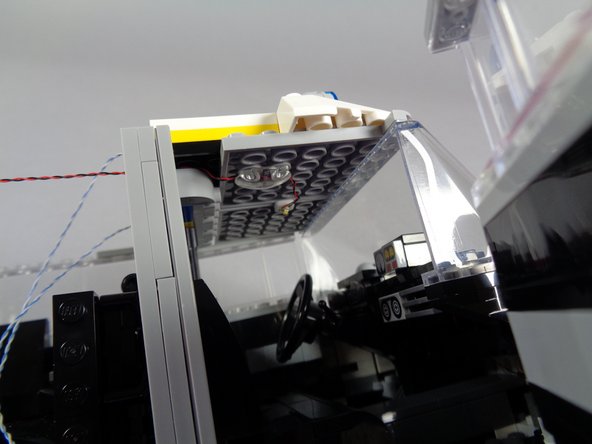 After you have re-attached the front to the top of the windshield, press down on the back of the front roof section to re-attach it to the bar behind the seats.