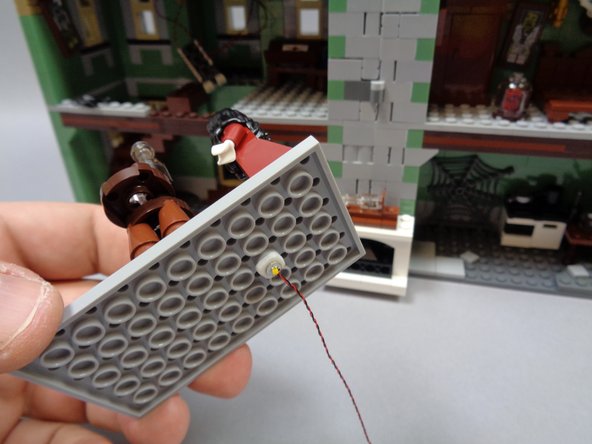 As shown in the third photo, attach the warm white light to the underside of the floor as shown, in the center and toward the front as shown.