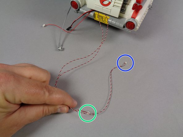 As shown in the first photo for this step, take the two lightbar control wires and compare lengths.  One wire will be shorter (as shown by the green circle in the first photo) and the other wire will be longer (as shown by the blue circle).