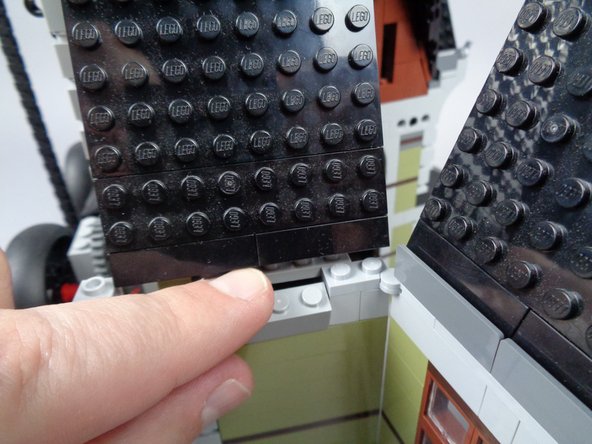 As shown in the photos for this step, re-attach the LEGO parts you removed in the earlier steps to rebuild the wall.