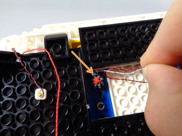 As shown by the green arrows in the second photo, turn the rear roof section upside down and route the three light wires through the holes in the Technic bricks under the roof, back toward the rear.