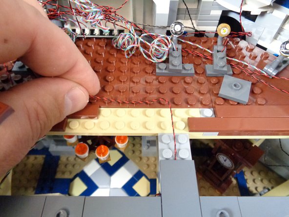 As shown in the first and second photos for this step, continue running the light wires from each torch back toward the TRUNK08 master controller.