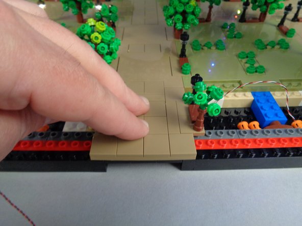 As shown in the photos for this step, re-attach the small panel between Sections 1 and 2 that you removed earlier.