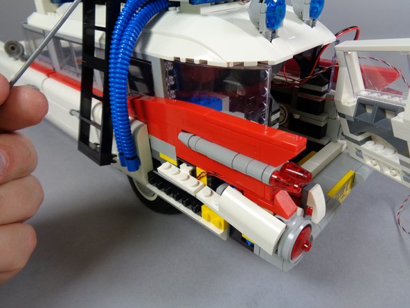 As shown in the photos for this step, re-assemble the left tail light.