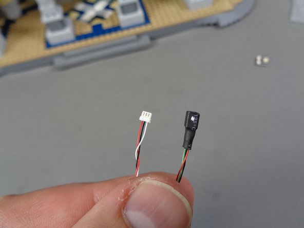 Also in the &quot;Lower Level Lights and Parts&quot; bag, there will be another custom cable with ends like the ones shown in the first photo.  One end will have a small 3-wire connector and the other end will have a small black connector with a white dot on one side.