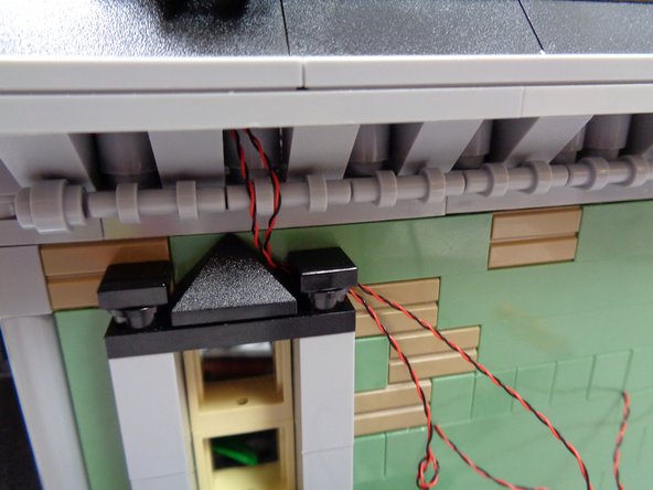 As shown in the second photo, you can use the top of the second floor window frame to hold the attic wires in place.