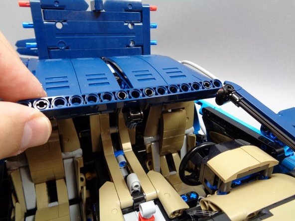 As shown in the third photo, tilt up the front Technic beam to make it easier to remove the center mount.