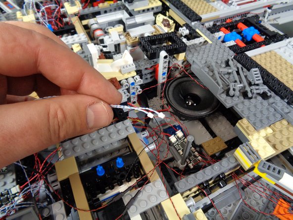 As shown in the photos for this step, continue routing the laser light wires up toward the second BRANCH09X adapter board.